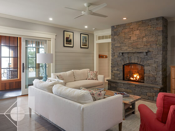 Family room with stone fireplace and doors to the outside.