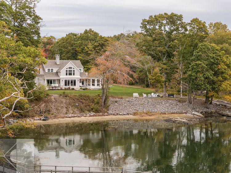 View of Boothbay Harbor home featuring garage and wrap around porch.