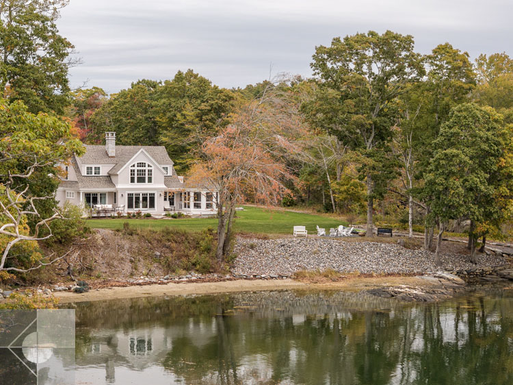 View of Boothbay Harbor home featuring garage and wrap around porch.