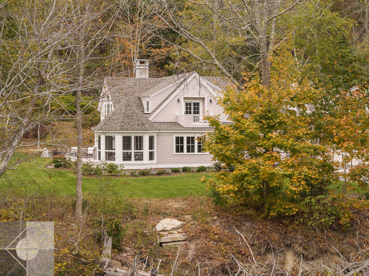 View of Boothbay Harbor home featuring garage and wrap around porch.