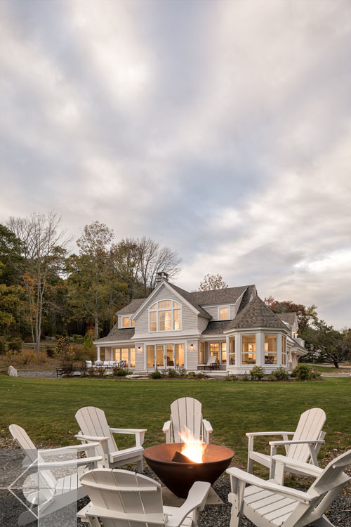 View of Boothbay Harbor home featuring garage and wrap around porch.