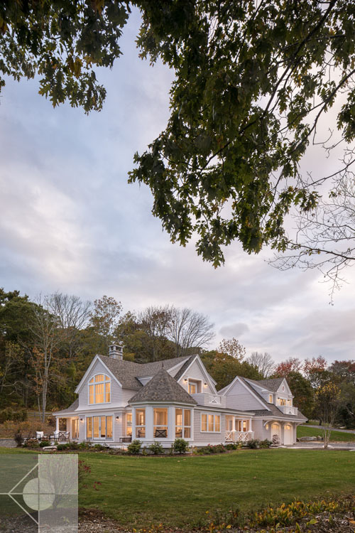 View of Boothbay Harbor home featuring garage and wrap around porch.