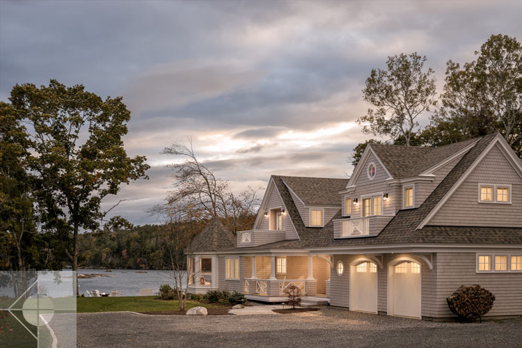 View of Boothbay Harbor home featuring garage and wrap around porch.