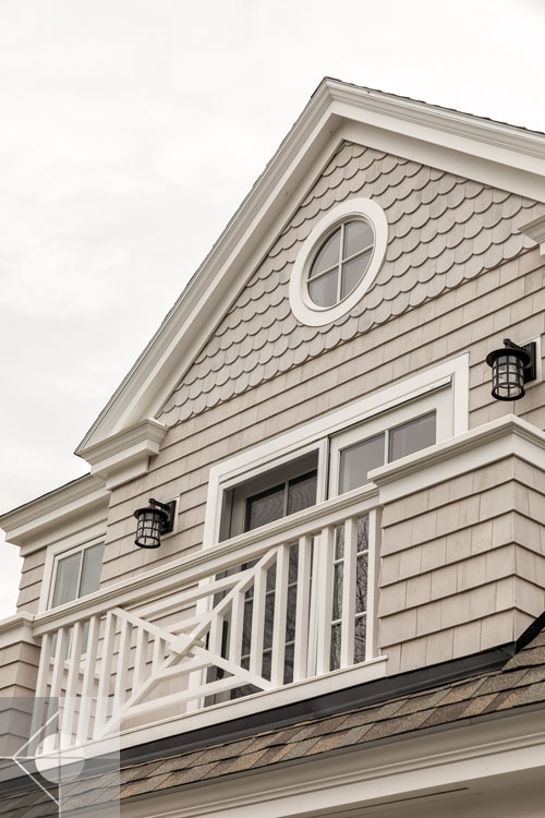 View of Boothbay Harbor home featuring garage and wrap around porch.