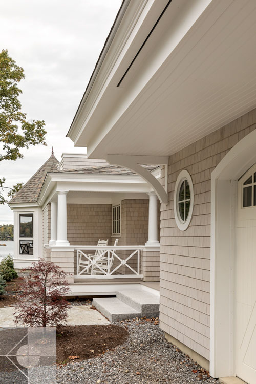View of Boothbay Harbor home featuring garage and wrap around porch.