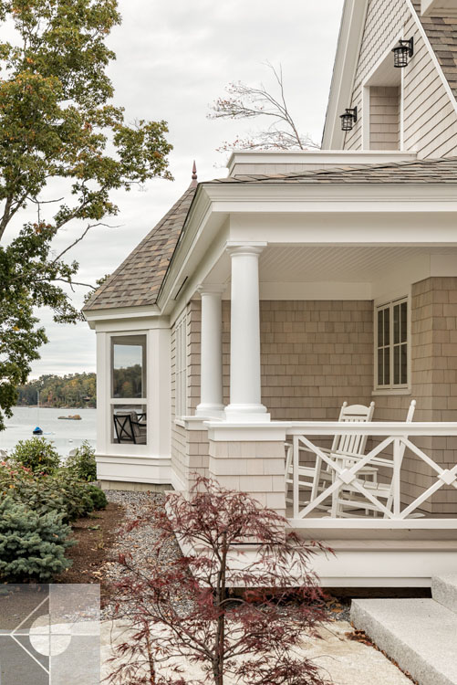 View of Boothbay Harbor home featuring garage and wrap around porch.