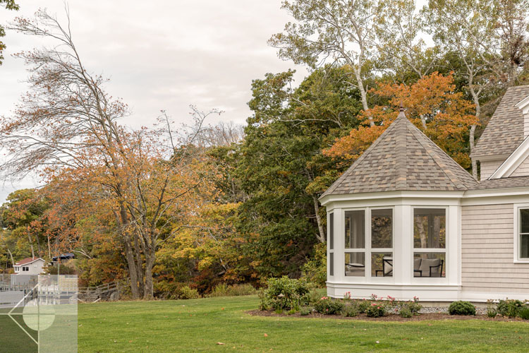 View of Boothbay Harbor home featuring garage and wrap around porch.