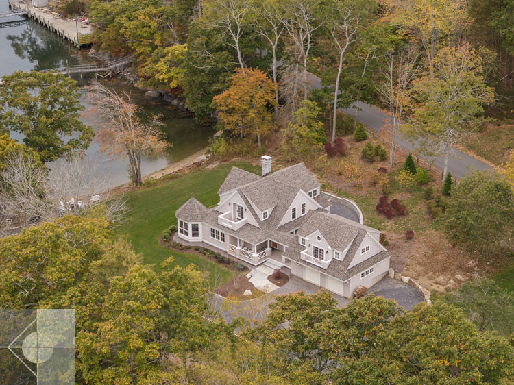 View of Boothbay Harbor home featuring garage and wrap around porch.