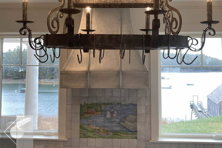 Chandlier above the kitchen stove and counters with water views.