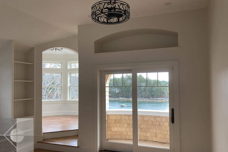 Great room overlooking the walkout deck and the interior of oxagon room, both with water views.