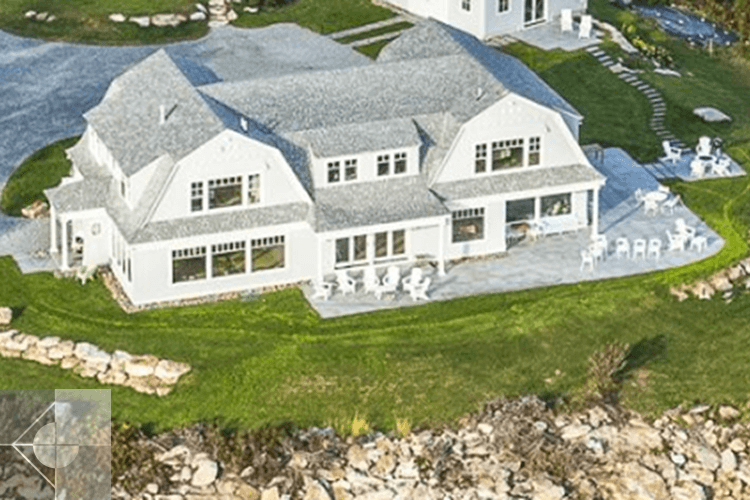 Drone image of Southport Island home with stone outdoor area overlooking the ocean.