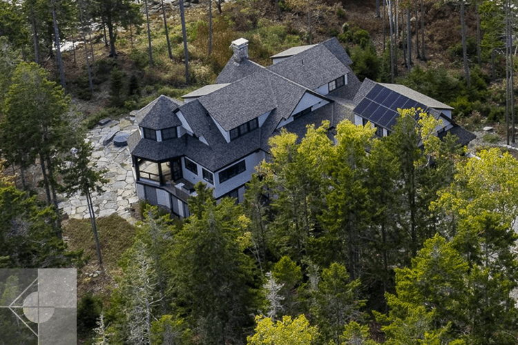 St. George, Maine drone photo of the house with solar panels and fieldstone patio.